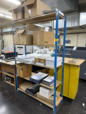 une grande pièce remplie de cartons, avec encore plus de cartons sur les étagères
