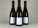 trois bouteilles de vin posées sur une table l'une à côté de l'autre