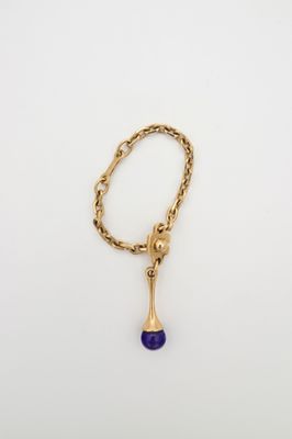 un collier en or orné d'une pierre bleue