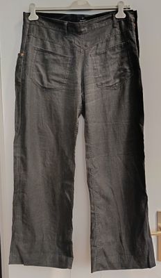 grey pants hanging on a hanger in front of a white door