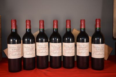 six bottles of red wine are lined up on a table