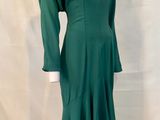 a green dress on a mannequin stand with a white background