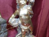 a statue of a child holding a bird next to a lamp