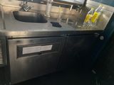 un évier en inox sur lequel est posée une bouteille d'eau