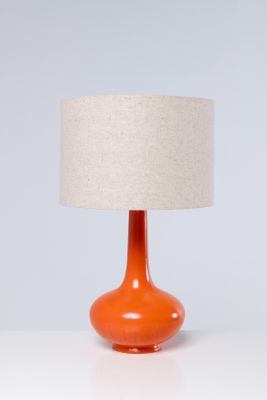 une lampe de table orange surmontée d'un abat-jour en lin