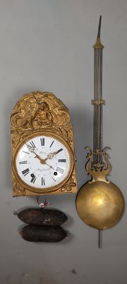 une horloge accrochée au mur à côté d'une bougie