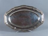 un plateau d'argent antique sur un support sur fond gris