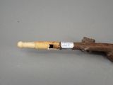 a small wooden pipe with a stick sticking out of it