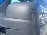 the side view mirror of a blue van with a blue sky in the background