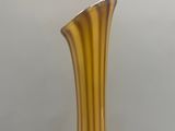 yellow glass vase sitting on a table against a white background