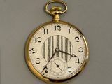 une montre de poche en or accrochée au mur