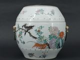 un vase blanc sur lequel sont peints un oiseau et des fleurs