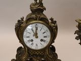 two clocks sitting next to each other on a table