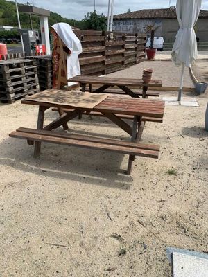 une table de pique-nique et un parasol installés sur le sable