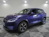 un SUV Nissan violet garé sur un sol à damier dans un garage