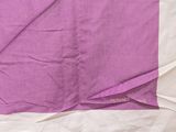 purple and white blanket on a bed with a white pillow
