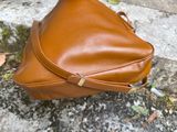 a brown bag sitting on the ground next to a brick wall