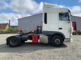 a white semi truck parked in front of a building