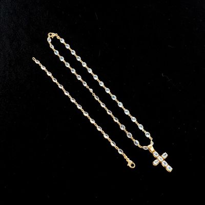a gold rosary necklace with a cross on a black background