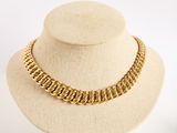 a close up of a gold chain necklace on a mannequin