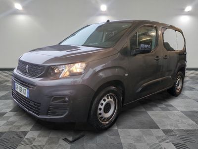 la camionnette grise est garée sur le sol en damier d'un garage