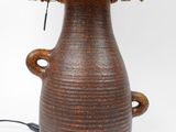 a brown vase with a lamp on top of it