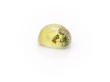 a close up of a yellow and green gemstone on a white surface