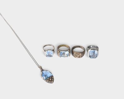 trois bagues, un collier et un collier avec un pendentif sur fond blanc