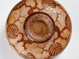 a brown and white vase sitting on a white surface