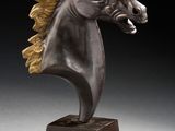 sculpture en bronze représentant une tête de cheval, posée sur un socle en bois