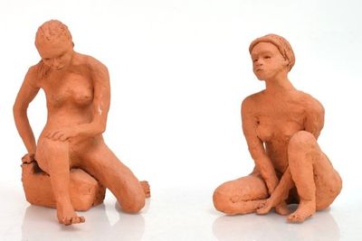deux figurines représentant un homme et une femme assis par terre