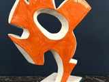 orange and white sculpture of a fish on a marble base