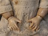 a close up of a doll ' s hands on a dress