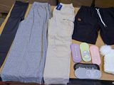 several pairs of pants, mittens, and shoes are laid out on a table