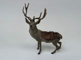 a small toy deer that is standing on a white surface