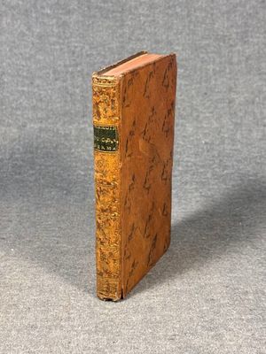 an old book sitting on top of a table next to a gray surface