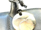a black purse that has a silver coin on it
