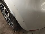 a close up of a car ' s front bumper with a denting on it