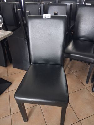 a lot of black leather chairs in a restaurant