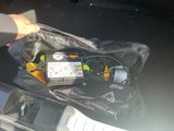 une personne tenant un sac rempli d'appareils électroniques à l'arrière d'une voiture