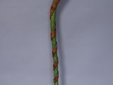 a wooden walking stick with a green and brown design on it