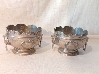 deux bols en argent posés sur une table, sur fond blanc