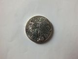 a close up of a silver coin on a white surface