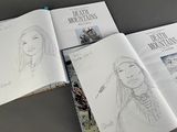 sketches of a woman in native clothing sitting on a table in front of a book