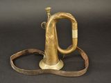 an old brass trumpet with a leather strap on a black background