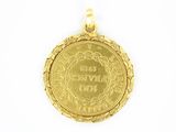 a gold coin pendant with the date of the birth of a woman