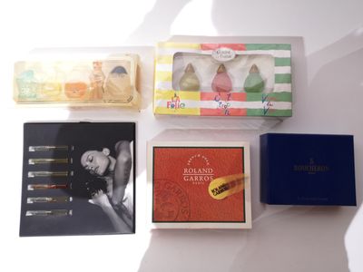 quatre boîtes de parfums différentes posées sur une surface blanche
