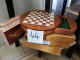 une table en bois sur laquelle se trouvent un échiquier et une boîte