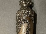 a silver spoon with a clock on it sitting on a table