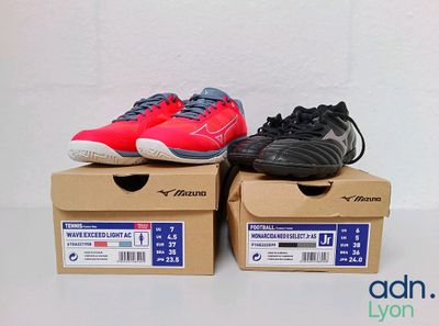 une paire de chaussures de tennis rouges et noires posée sur une boîte en carton